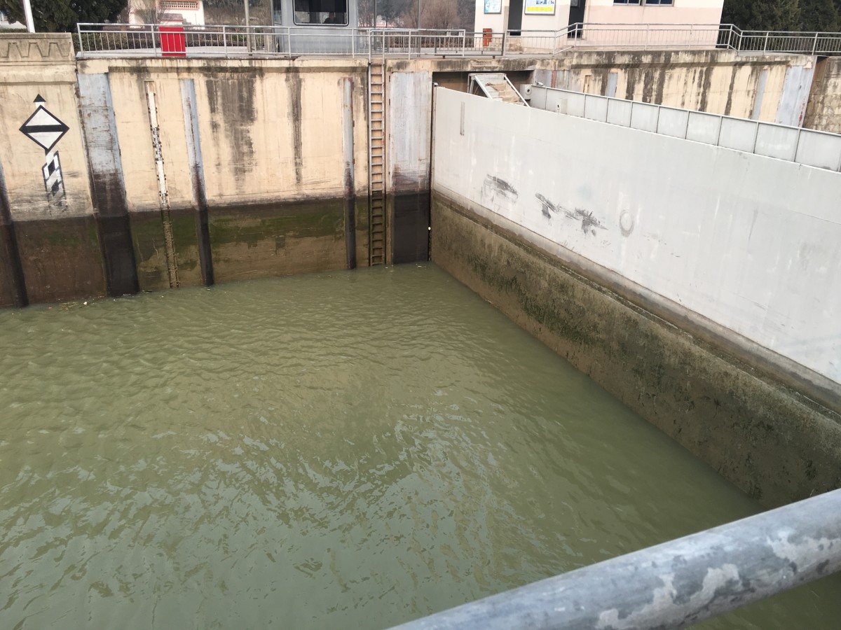 闸门底部的阀门开启，闸室内部开始缓缓泄水，消除闸室内部与下游河段的落差